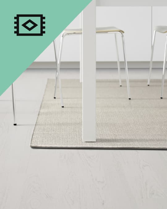 Tapete bajo sillas blancas