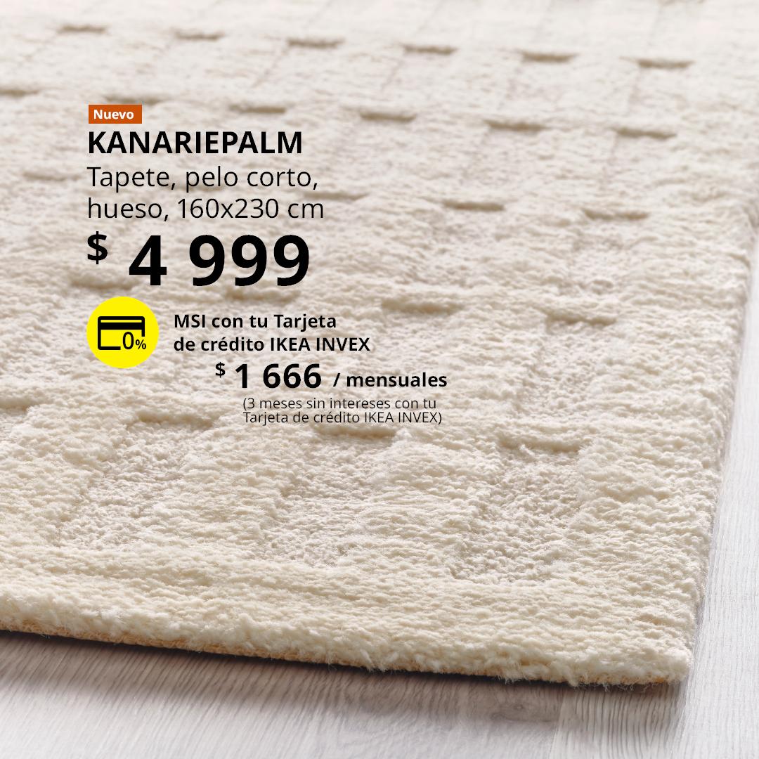 Tapete KANARIEPALM color hueso de pelo corto, colocado sobre un piso de madera clara.