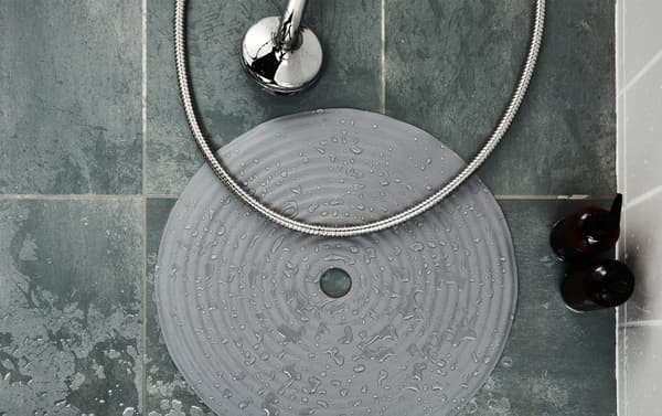 Tapis de douche posé sur le sol humide d’une douche