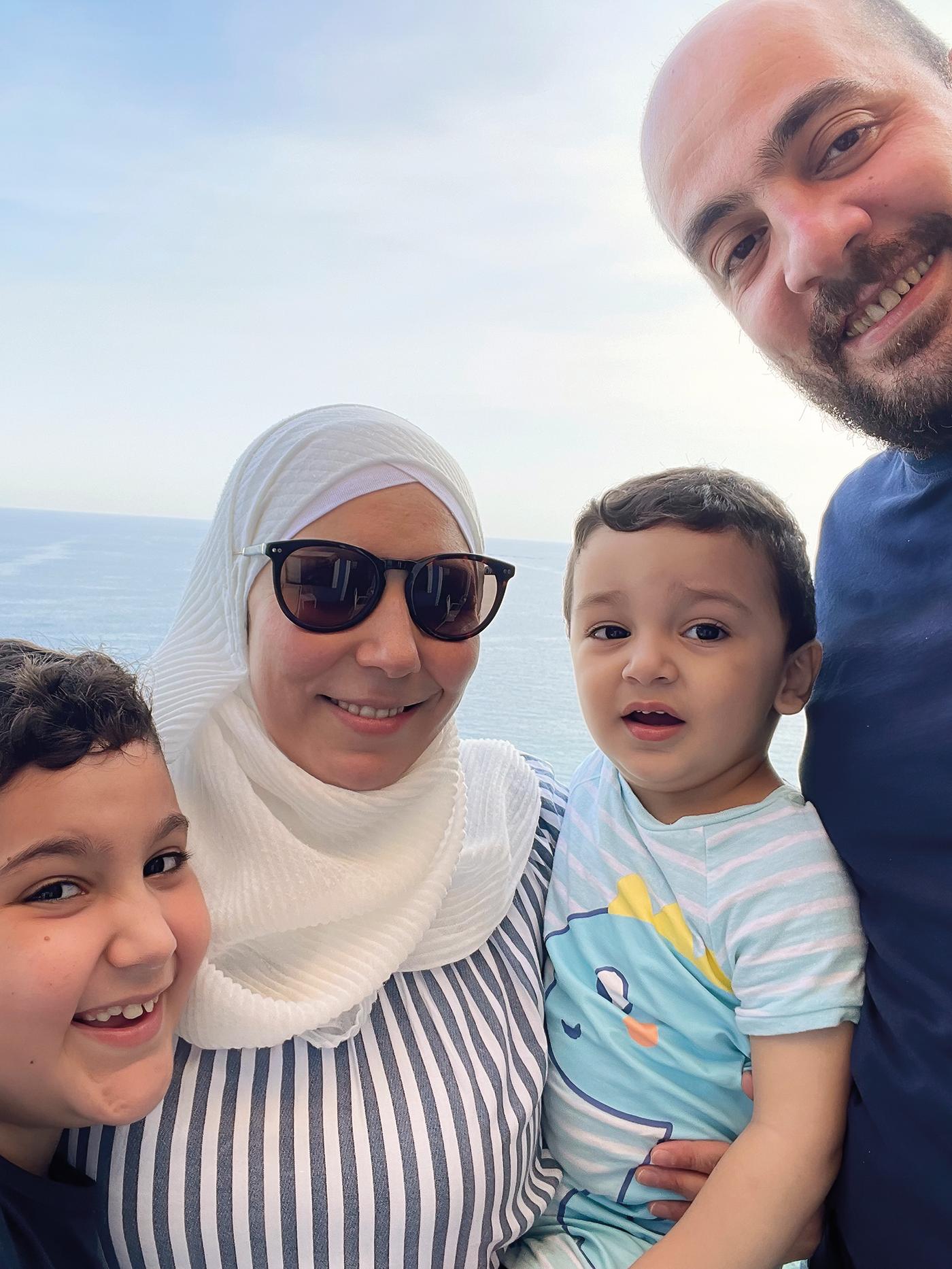 Tarek, refugiado sírio e colaborador IKEA com a sua esposa e dois filhos com o mar ao fundo.