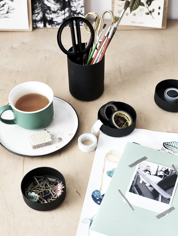 Tasse de thé et fournitures sur un bureau en bois.