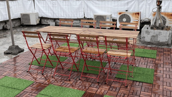 テーブルと椅子のセットが配された屋外スペース。