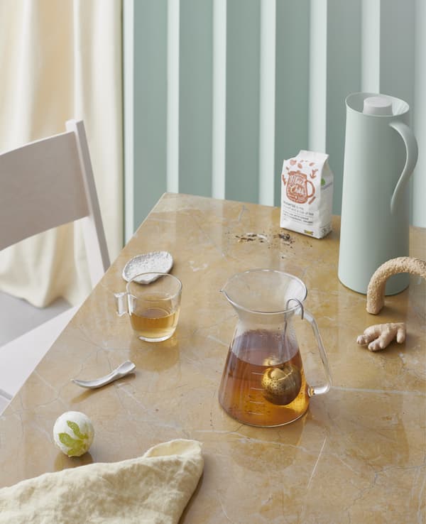 Tea in a glass teapot and cup on a table.