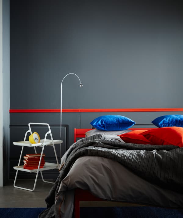 Tempat meletak dulang dua para VIGGJA IKEA berwarna putih digunakan sebagai meja sisi katil dengan lampu di sebelahnya.