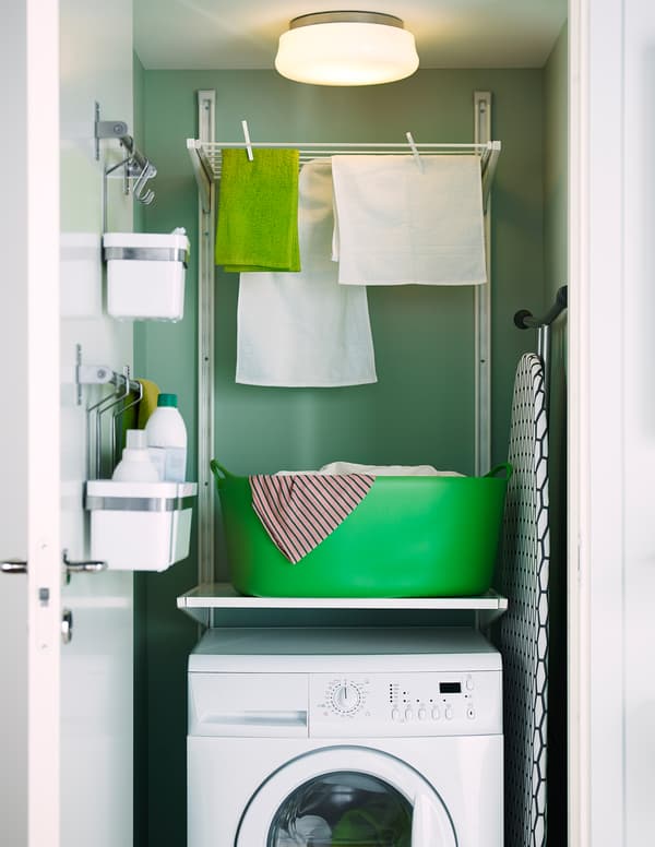Tendal de IKEA fixado á parede, enriba dunha lavadora nun armario.