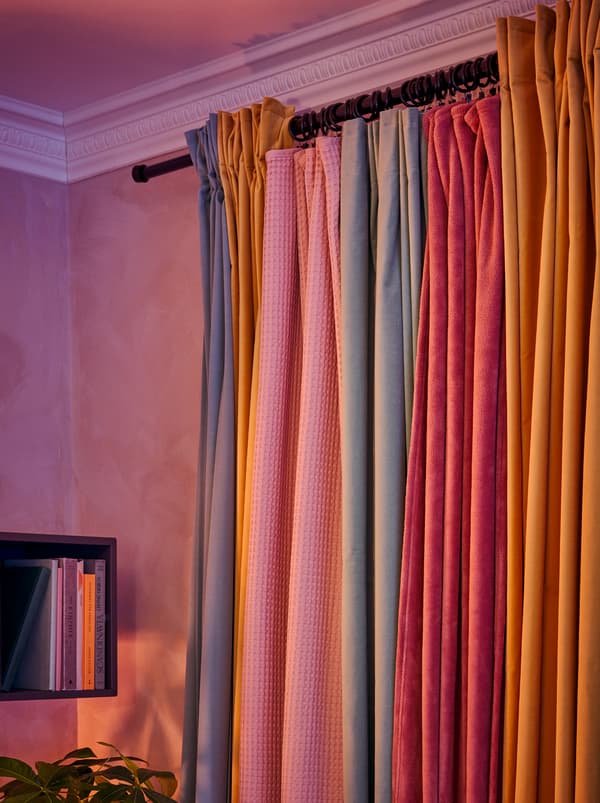 Tende appese a un bastone arricchite con tessuti fissati agli anelli per tende SYRLIG a formare una grande tenda, colorata e continua - IKEA