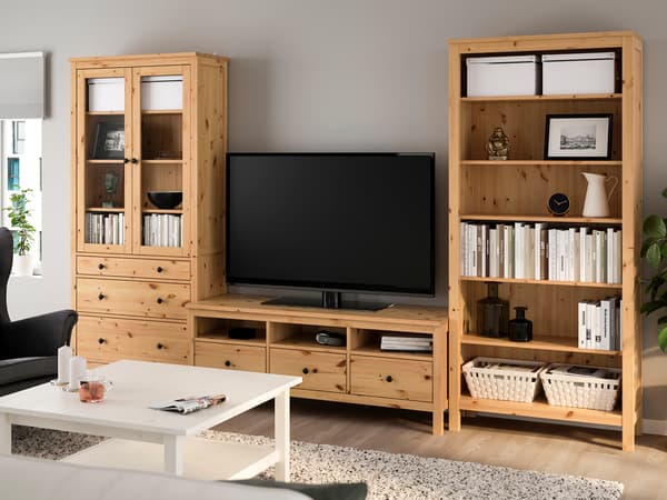 木製テレビボードと収納棚を置いたナチュラルリビング。白いテーブルと明るい床で温かみのある空間。