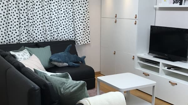 テレビの前にソファが置かれ、クッションやぬいぐるみが並んでいる。