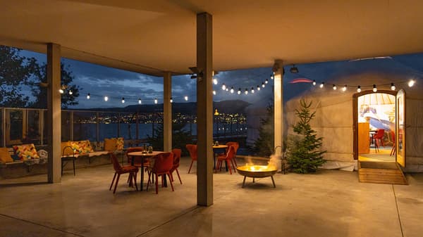 Terrace next to a yurt with tables and chairs and lighting with fairy lights