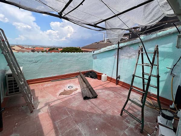 Terraza antes de ser reformada con escaleras y objetos sin ordenar.