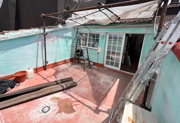 Terraza en obras con suelo y pared manchada. 