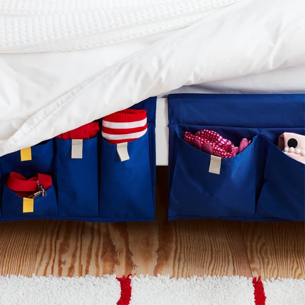 Textile storage with blue MÖJLIGHET bed pocket to keep things close at hand on the side of the bed.