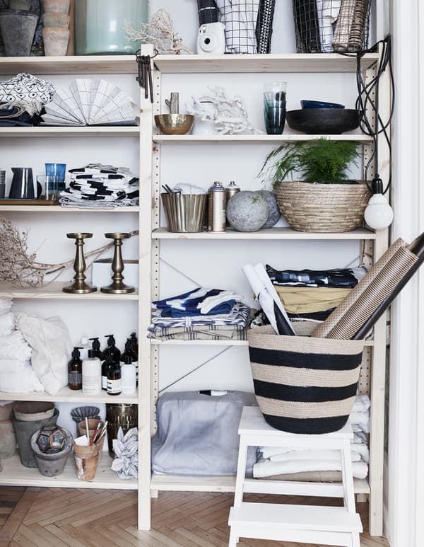 Textiles, plantes et objets décoratifs sur une étagère.