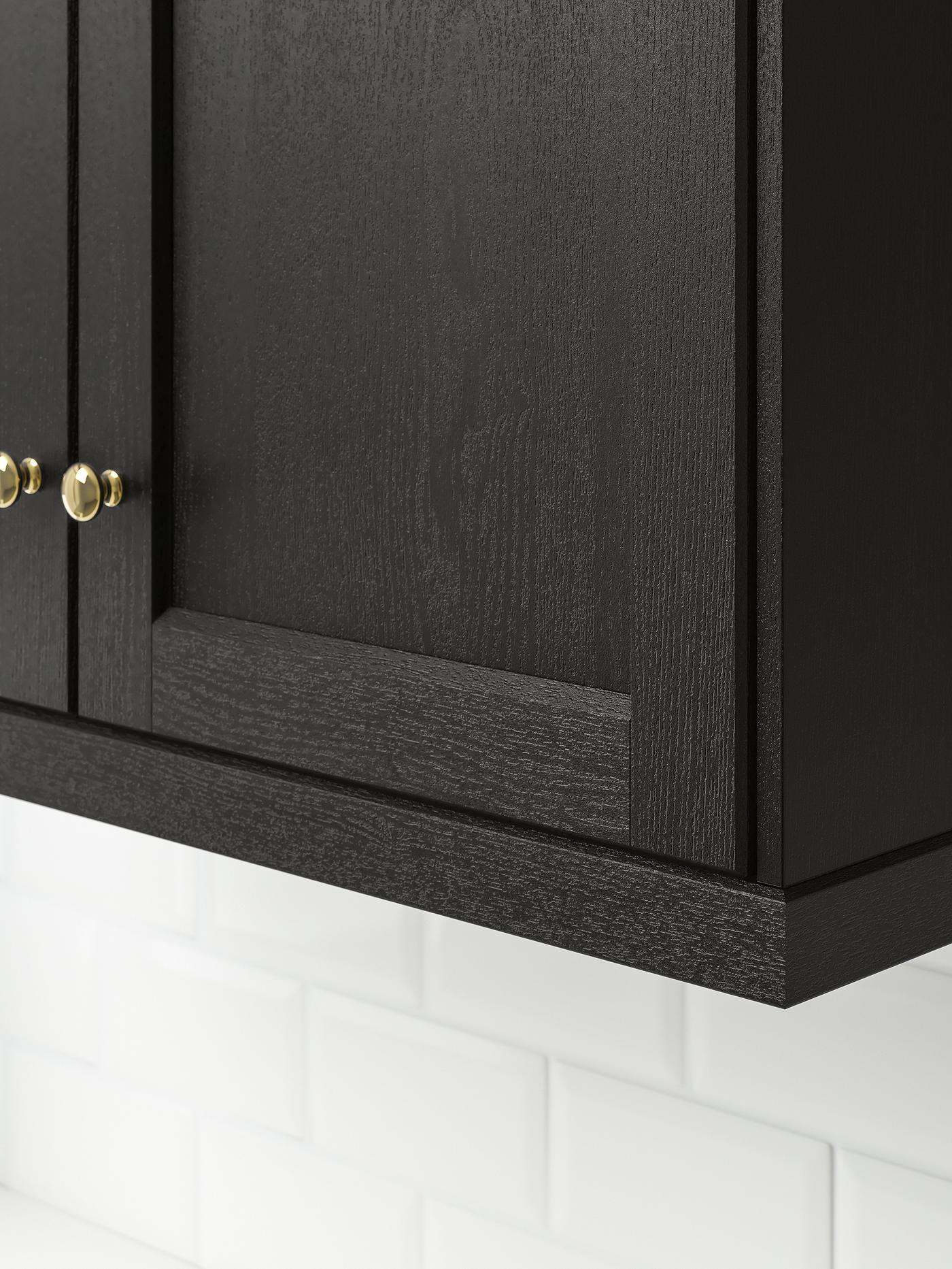 The bottom corner of a kitchen cabinet with LERHYTTAN doors in stained black.