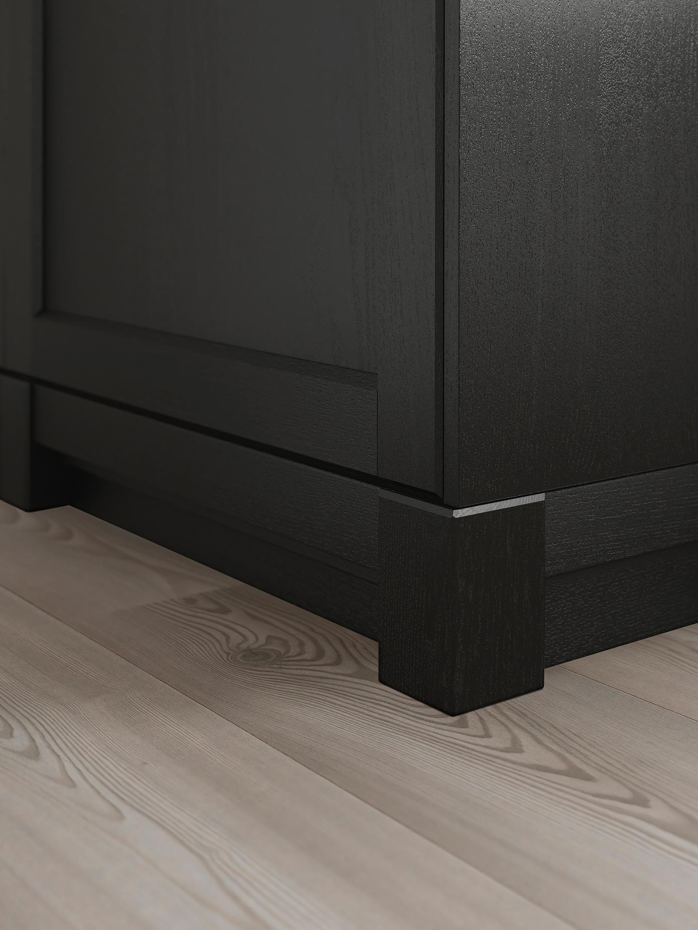 The bottom corner of a kitchen cabinet with LERHYTTAN doors in stained black.