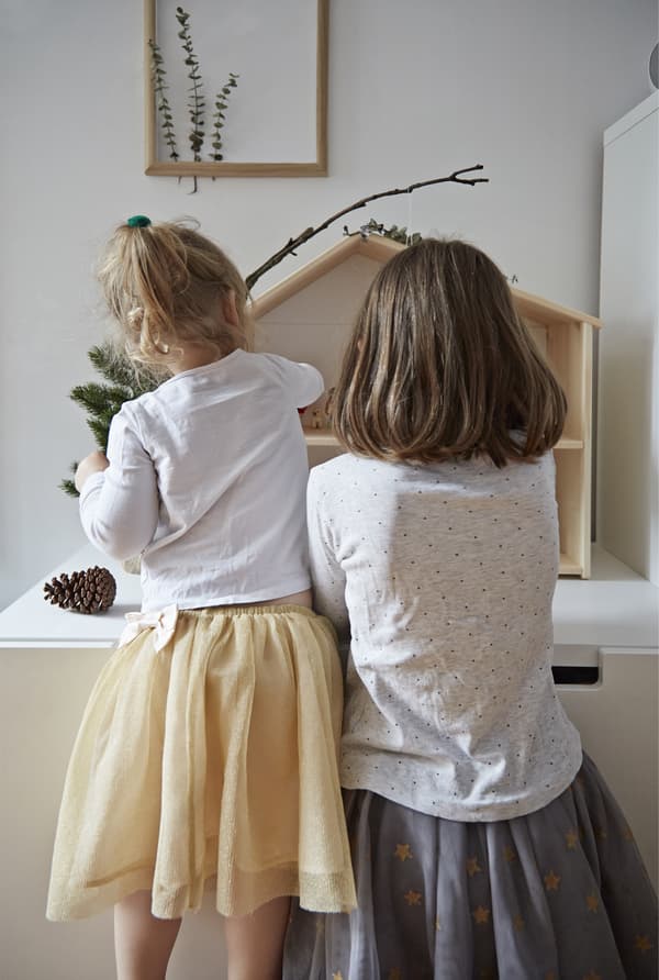 The children play with their doll’s house.
