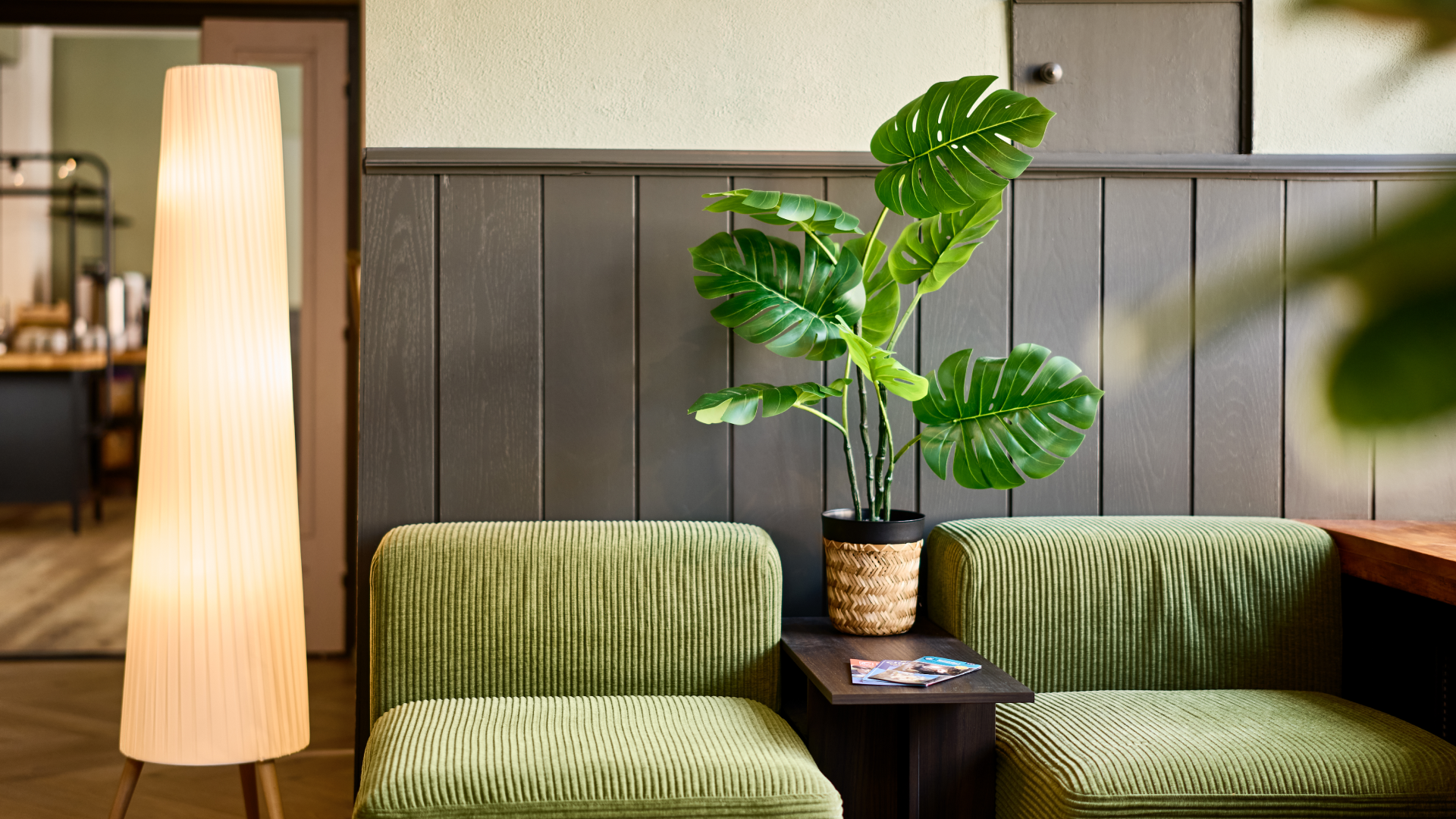 The lobby with green chairs and wood along the wall