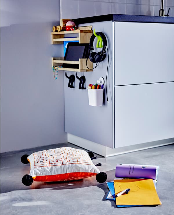 The side of a low kitchen cabinet with toys and stuff for children.