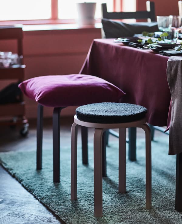 The stools at a dining table have extra padding and pillows for comfort.