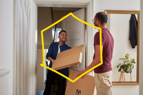 The transport worker hands a parcel to a customer.