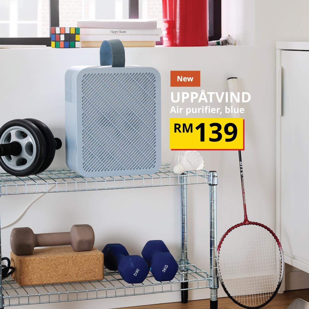 The visual shows a blue UPPÅTVIND air purifier placed on a wire shelving unit, surrounded by fitness equipment including dumbbells, a skipping rope and a badminton racket. The text reads: “New UPPÅTVIND Air purifier, blue, RM139.”