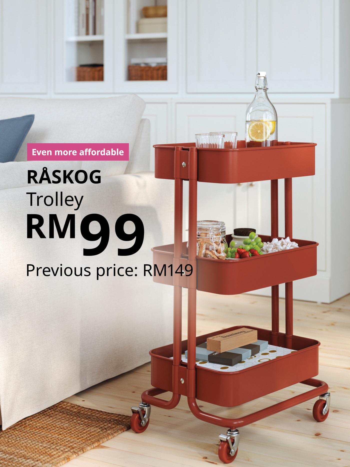 The visual shows a red RÅSKOG trolley filled with drinks, snacks and other items beside a sofa in a bright living room. The text reads: “Even more affordable. RÅSKOG trolley, RM99. Previous price: RM149.”