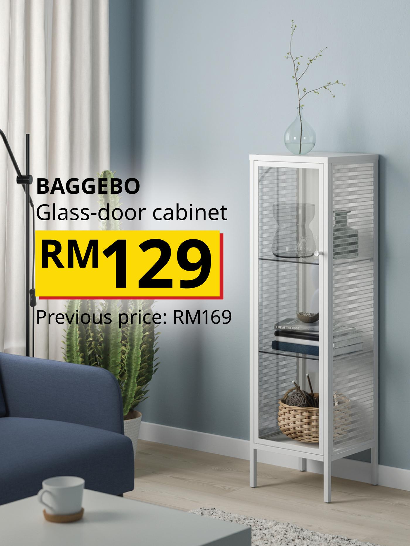 The visual shows a white BAGGEBO glass-door cabinet displaying home accessories and storage products in a living room. The text reads: “BAGGEBO Glass-door cabinet, RM129. Previous price: RM169.”