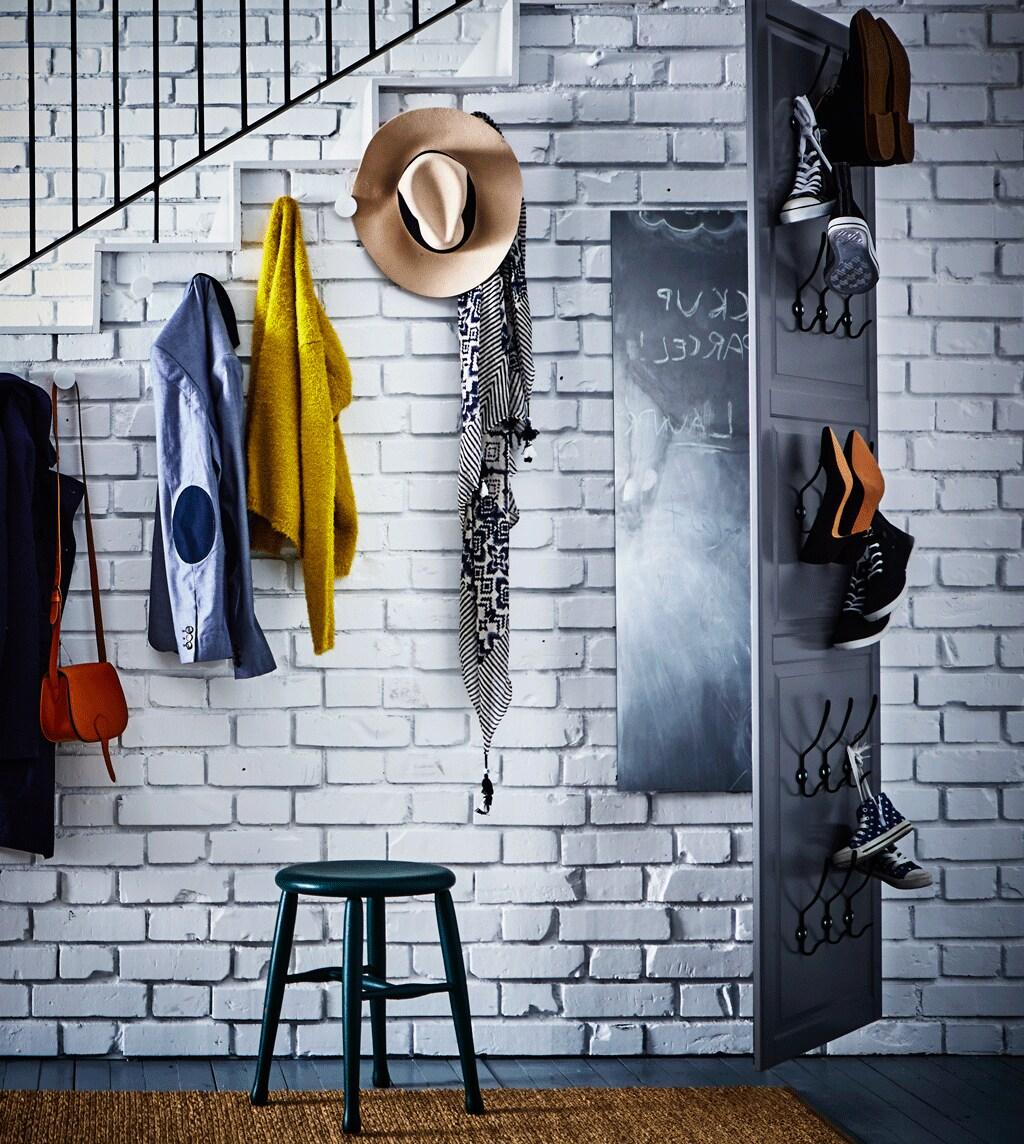 The wall on the side of the stairs with hooks wth coats and hats, and a big mirror as hallway.