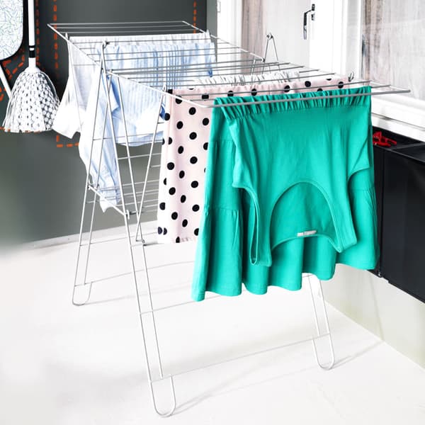 The white FROST drying rack with clothing hanging on it.
