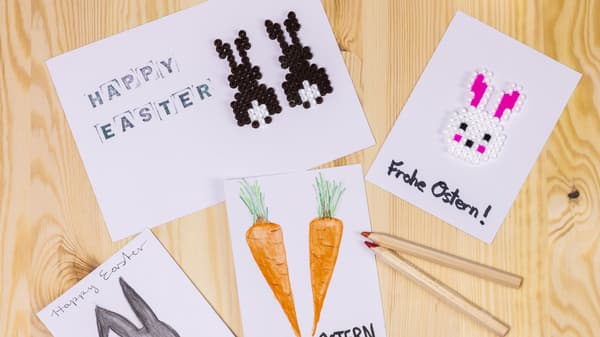 There are white pieces of paper with Easter decorations on them lying on a table.