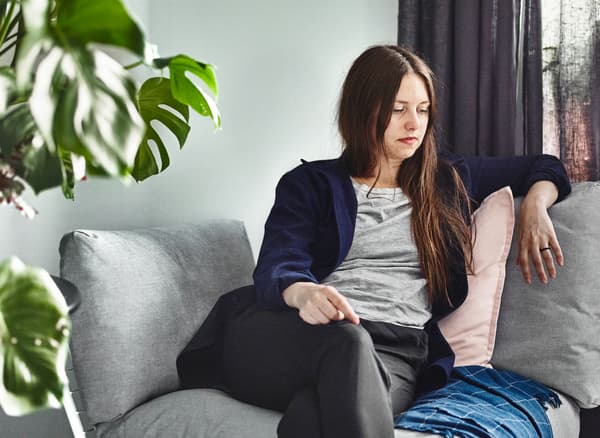 Therese Ericsson, una designer affermata che vive e lavora a Malmö, seduta su un divano.
