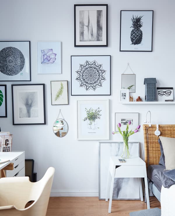 This gallery wall of Margo’s artwork blurs the line between bedroom and office.
