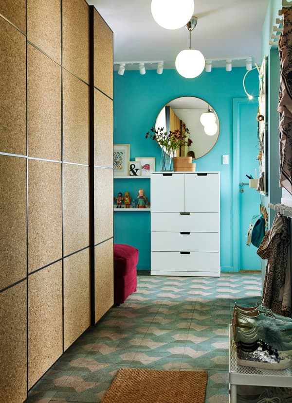 This small hallway has IKEA PAX wardrobe with KIRKENES cork sliding doors for clothes storage. It allows the family to show off their children’s creations.