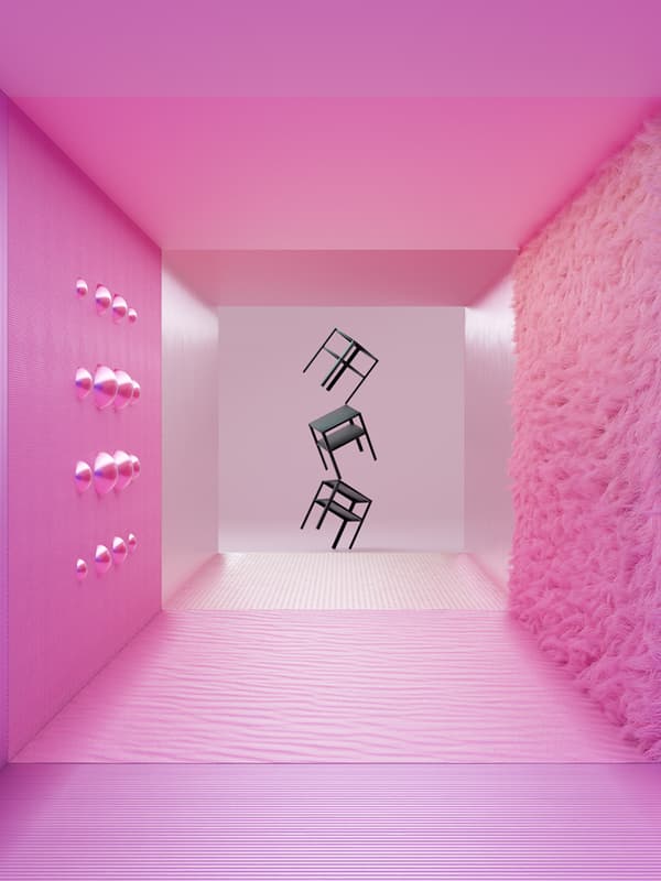 Three, black, KNARREVIK bedside tables balance on top of each other, one-legged, at the end of a pink corridor.