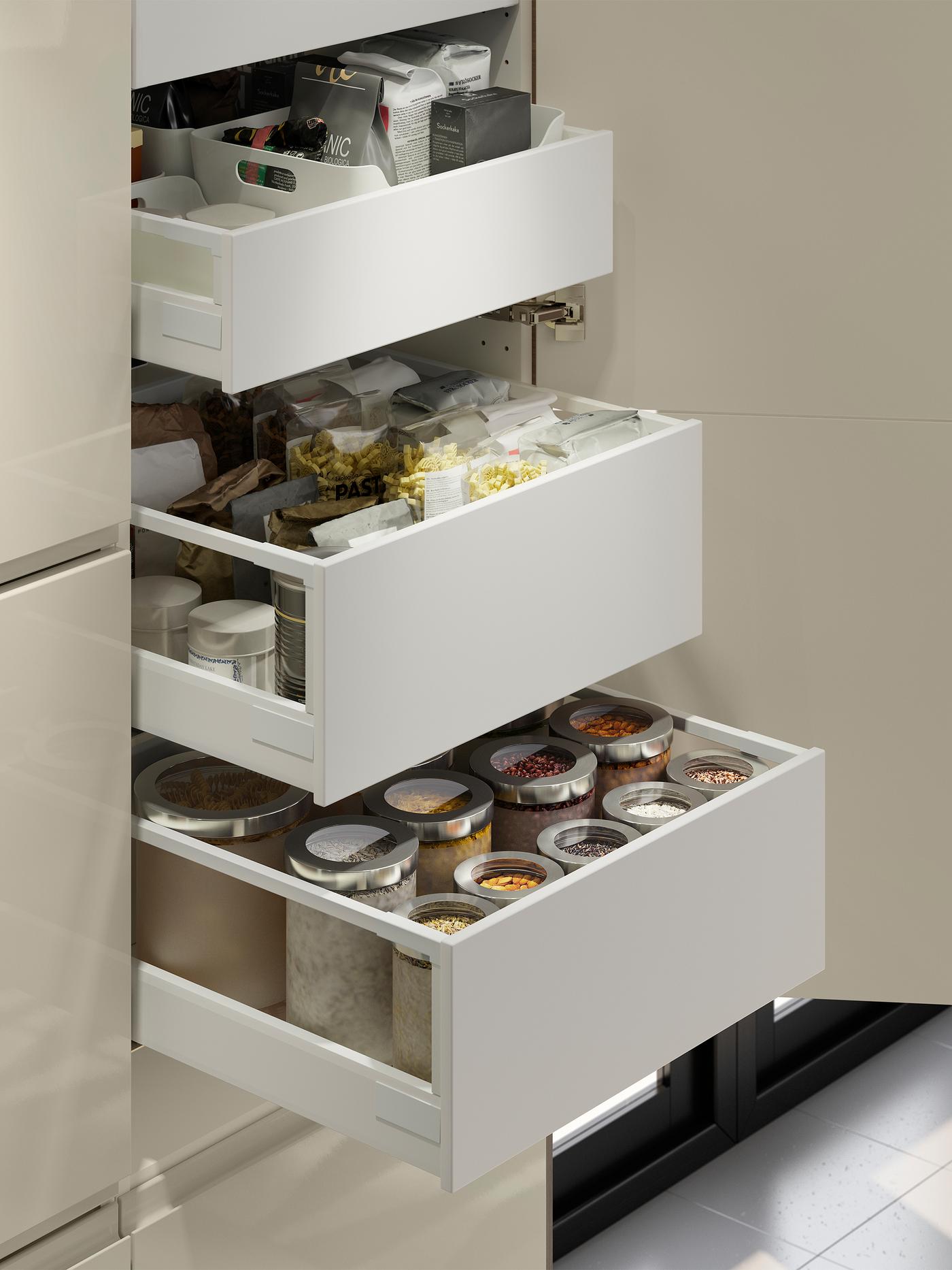 Three drawers inside a cabinet are pulled out showing stored dry goods inside.