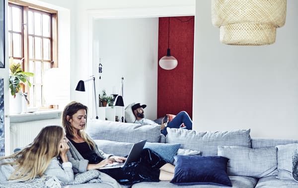 Three family members relaxing in a living room.