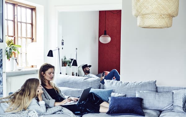 Three family members relaxing in a living room.