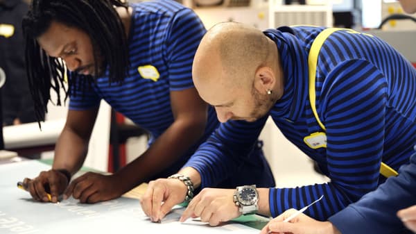 Three IKEA Coworkers creating a sign