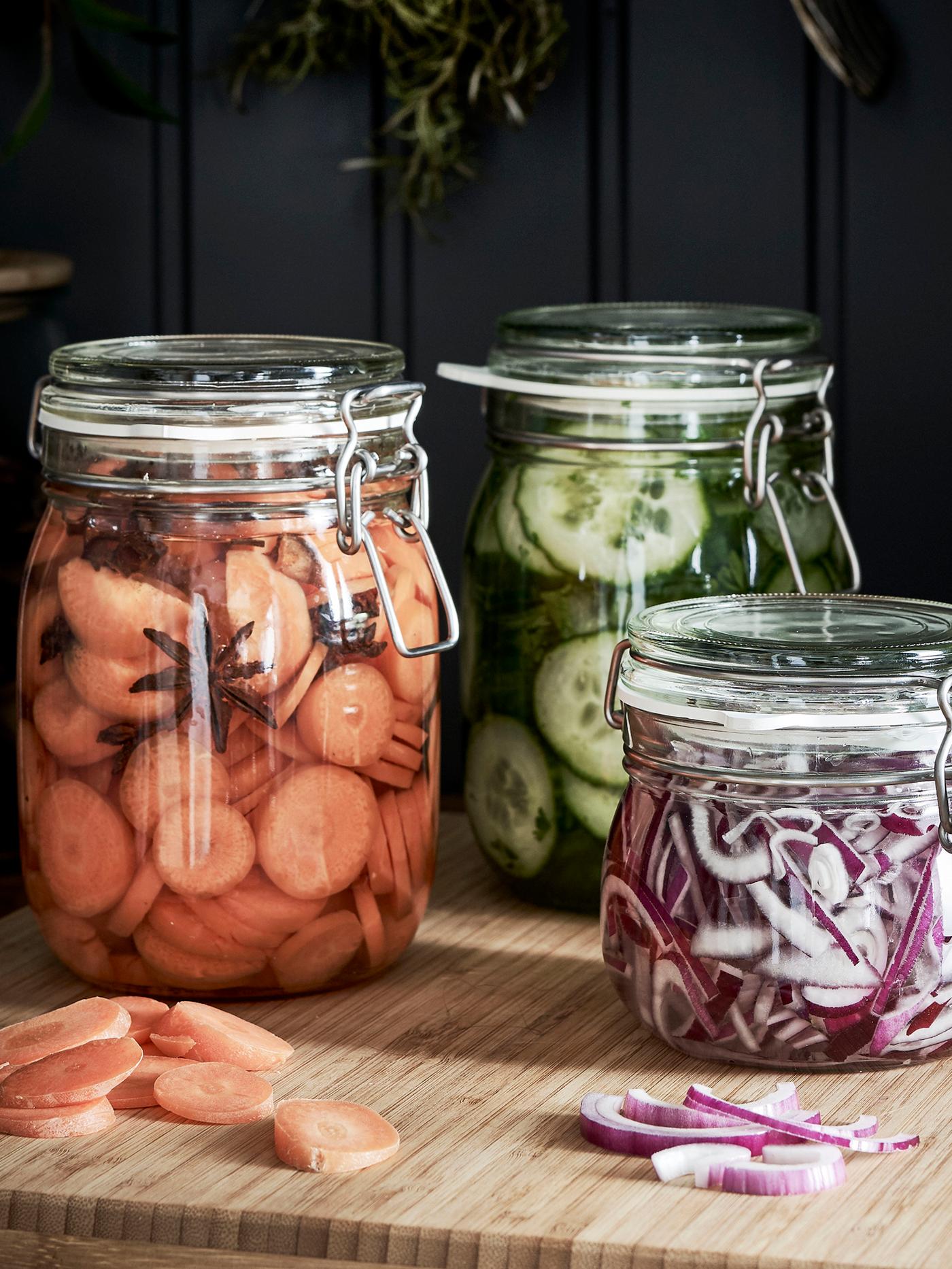 Three KORKEN glass jars with pickled vegetables inside