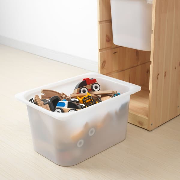 Three orange TROFAST boxes, and two miniature toy trucks on the floor against a green background.