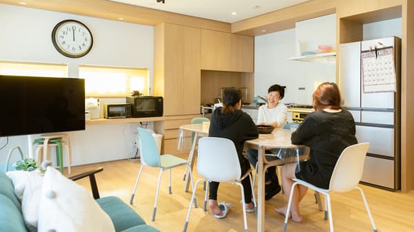 Three people having a conversation at a dining table.