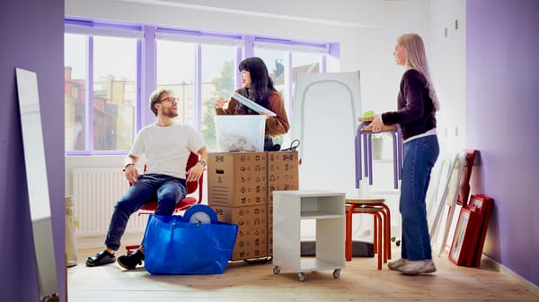 Three people packing up boxes with IKEA product