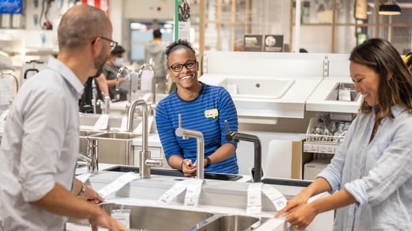 Three people talking around a sink