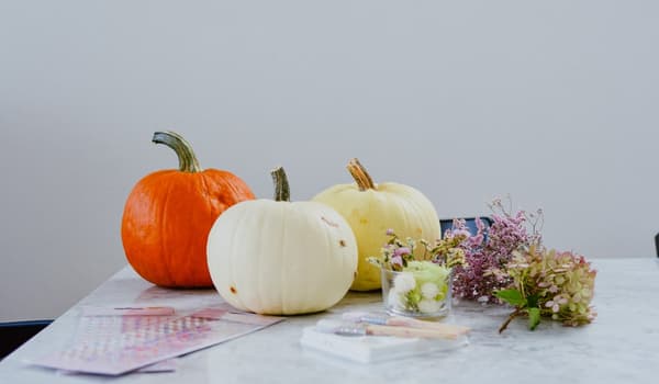 Three pumpkins, dried flowers and stickers on a table