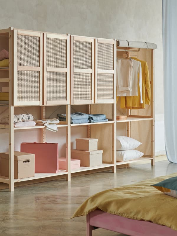 Three sections of IVAR storage system in light pine with four bamboo doors at the top, standing in a bedroom context.