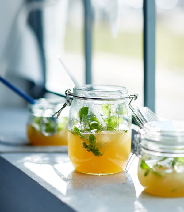 Three small jars filled with virgin Moscow mule sit on a windowsill.