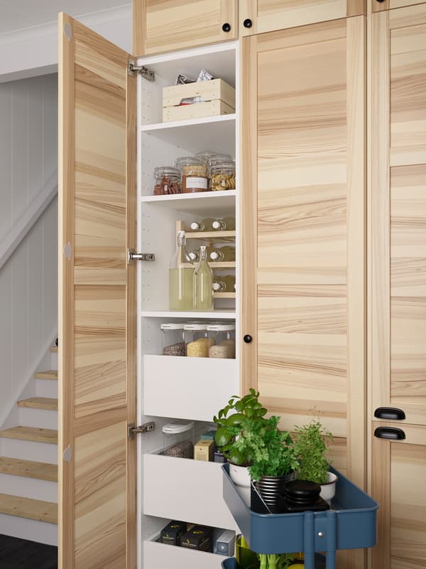 Three solid ash high cabinets. One has an open door showing shelves and drawers and there is a blue trolley in front.