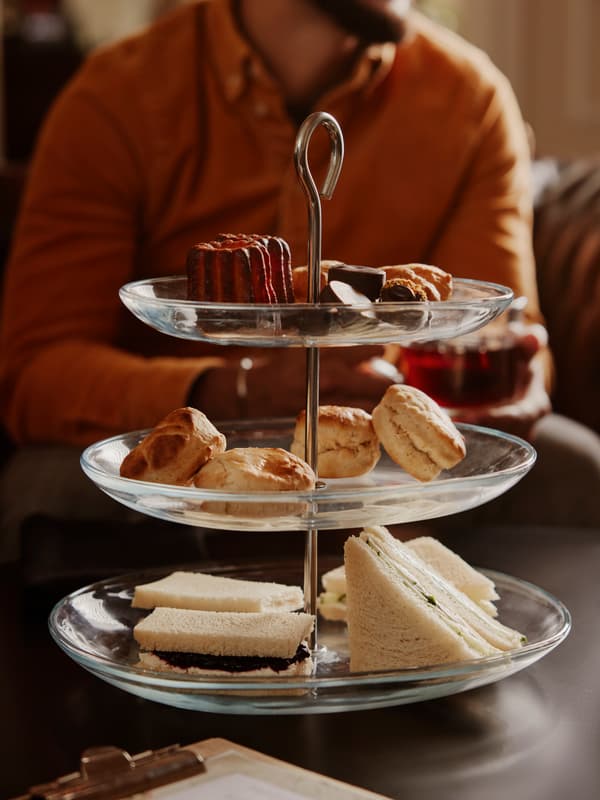 Three-tiered stand with sandwiches, scones, and pastries