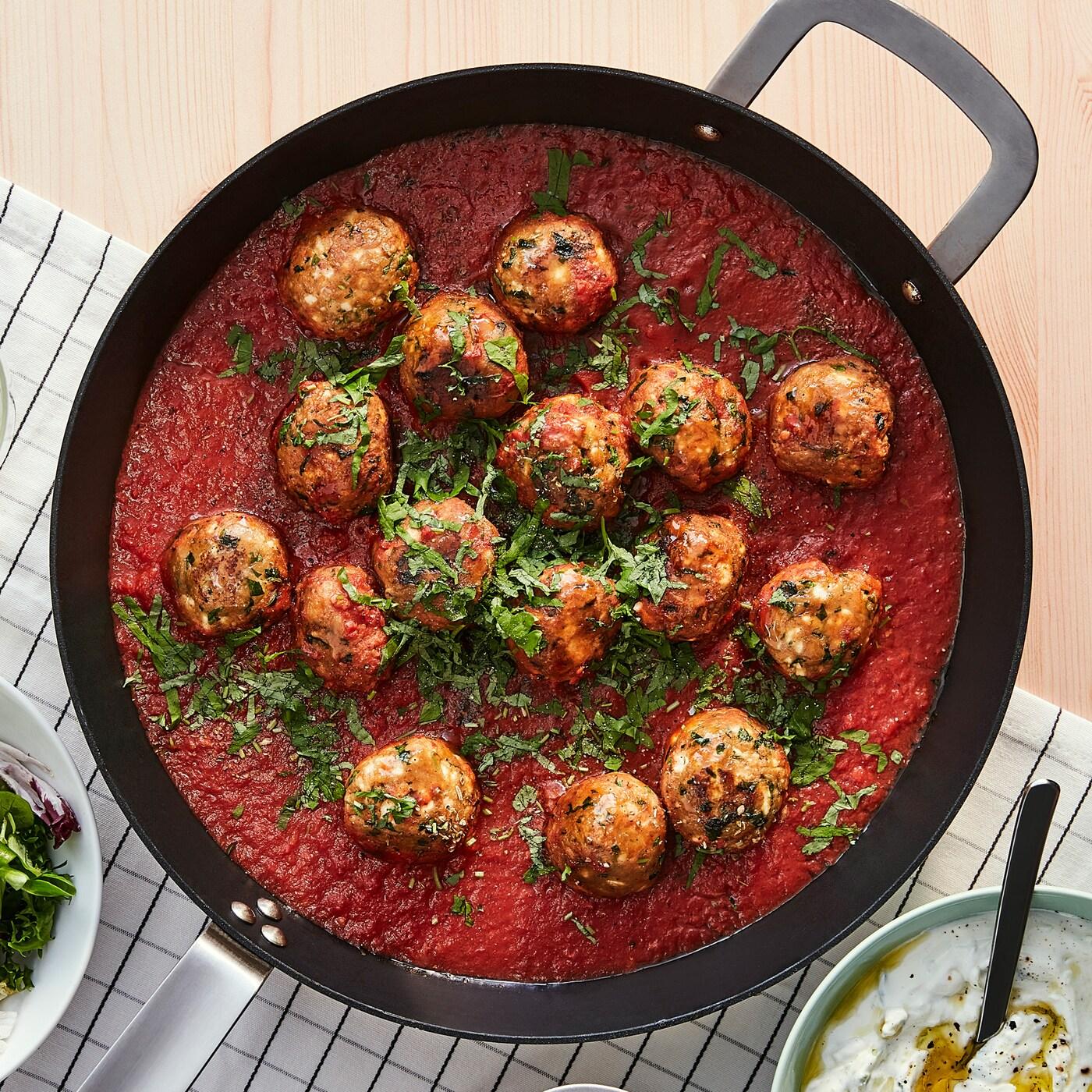 Tiganj s ćuftama od VÄRLDSKLOK biljne mešavine, u sosu od paradajza i pleh s pečenim krompirom.