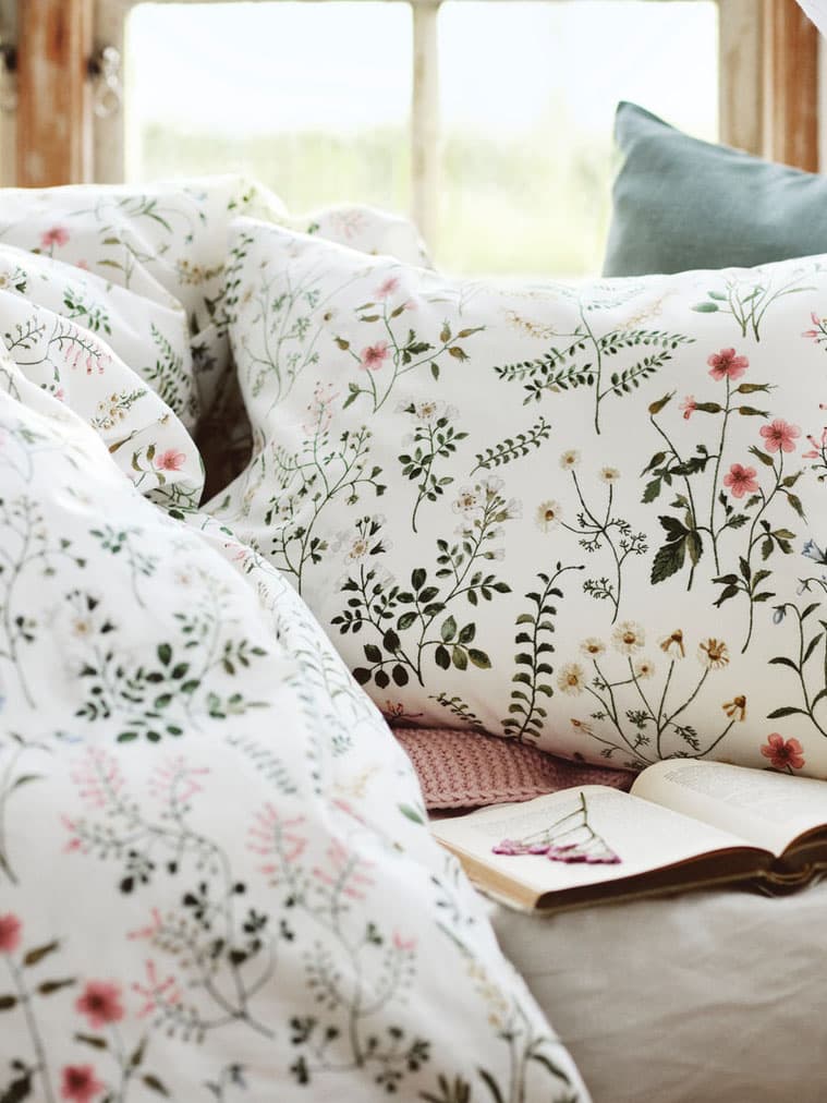 TIMJANSMOTT duvet cover with two pillow cases shown in an open bed.